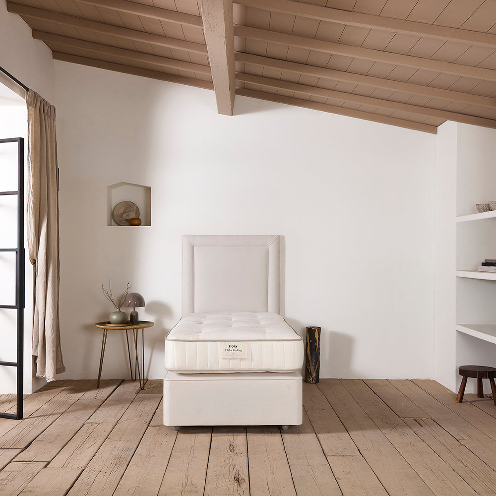 The Floks hand upholstered Reykjavik Headboard and deep divan base, pictured in a neutral fabric from the front.
