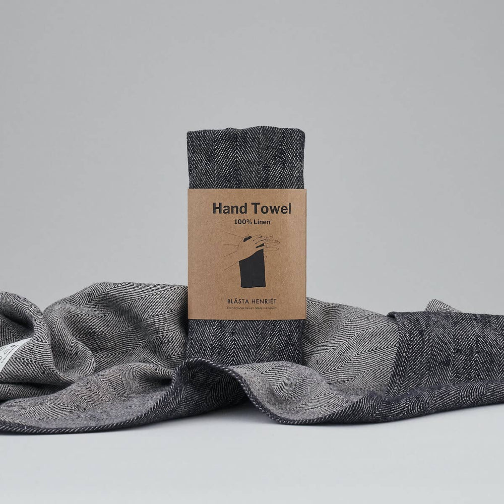 Blästa Henriët Hand Towel packaged product on top of a draped towel on a white background