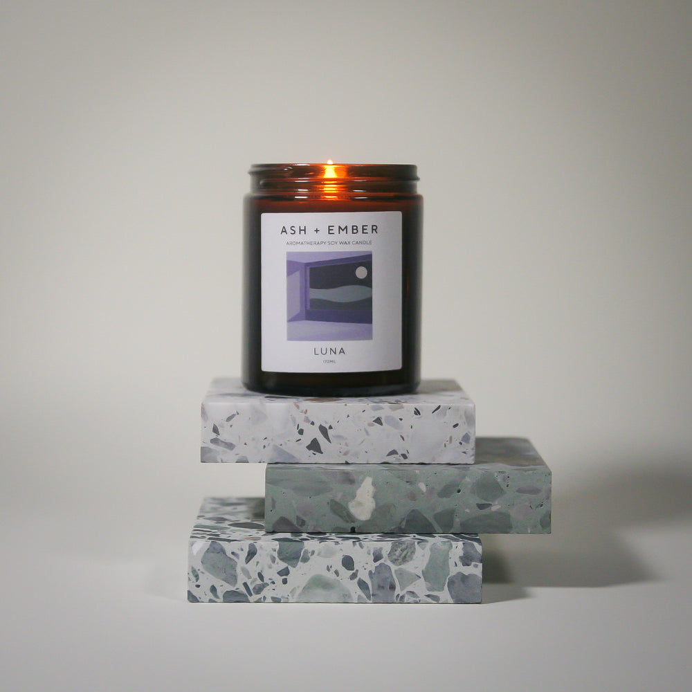 Ash + Ember Luna candle atop marble with white background
