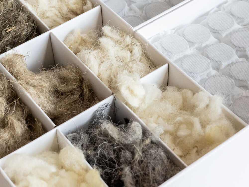 Close-up view of the Floks mattress construction showing natural UK-certified wool filling and high-quality pocket springs for superior comfort and support.